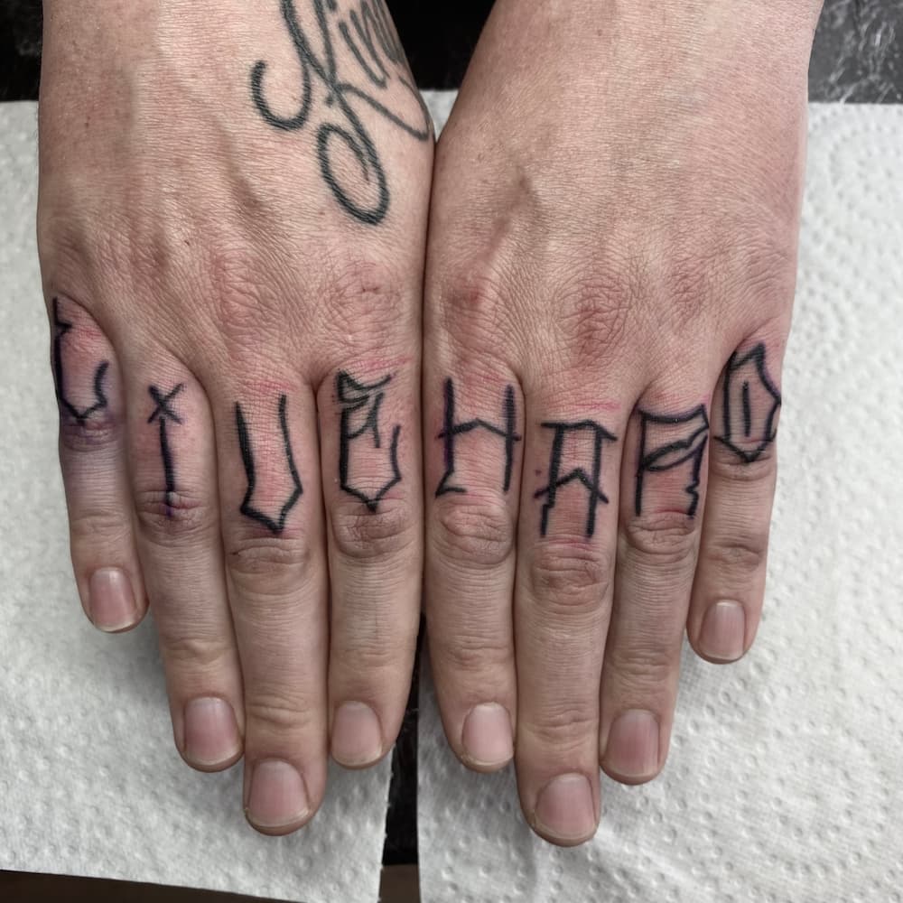 Lettering tattoo op de vingers door StayXGold Tattoo Barendrecht